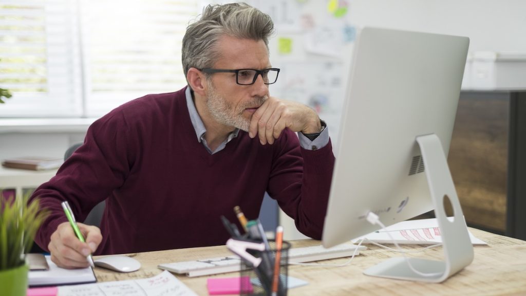 Pensive man working hard on computer