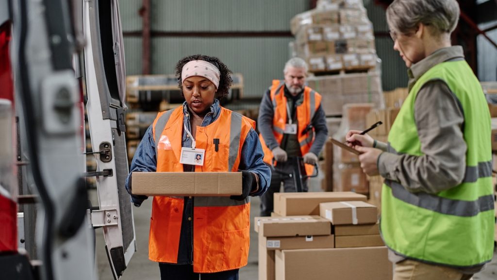 Foreman in reflective clothing filling the invoice and controlling the loading of cargo in truck SSUCv3H4sIAAAAAAAACpyTS47cIBCG95FyhxbrKQkM5pGrRFkUUHSj8dgjG08UjebuwXbbYZ2d66vir6c/v3+73ZjHJQf24/a5WdXOw7AuZcaSp7Fi/vLkM42R5pZ8zFLzFmBuLYq5THPGoYUeS3iM+EYVjuswbPhrd7KlYFkXWrZanihgoXvVOOAlcRT887Bvp2N31hfVxdhLw5bV7+xEh/h/vTw+fl0N32kMf/aCm0ZmGgiPRp41MmtklxRy6FxvQUkjwGrjwciQvLFCqI7OzExastxJC8nEvgZ3CC55DZwT+oqcJHMFi4iR+yiAkDwooSJgRA1orXKuQ6+kvIK9VYFSMmBClKA6FcC6moMnSj5J7KT/p9xb7IMKHRCPVTmlBJgQgXTg0QSXdNRXsMbUd9Ja0FYLUNb0YIlzEKbvtBGcaov7GI/Zsdffhea3dte4xjw1a/6YAg5bgGxG+z7nkMd782wqj/0qz2dhWscybzu5VsmGaXpHP2w3l6omnfyBy1LD48mbRKH+A9Nbk2ecyr7RpyqL9TQ3U0gplep6wbVR1unePgOOc37kqrOXcwpVO7zm2LaetwqYq0PVPkYwOtYbEUGB9cHVyfey114pn0Id4ddfAAAA//8DAP+PCsi3AwAA