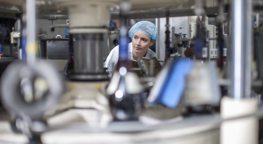 Lab technician checking equipment at packaging factory