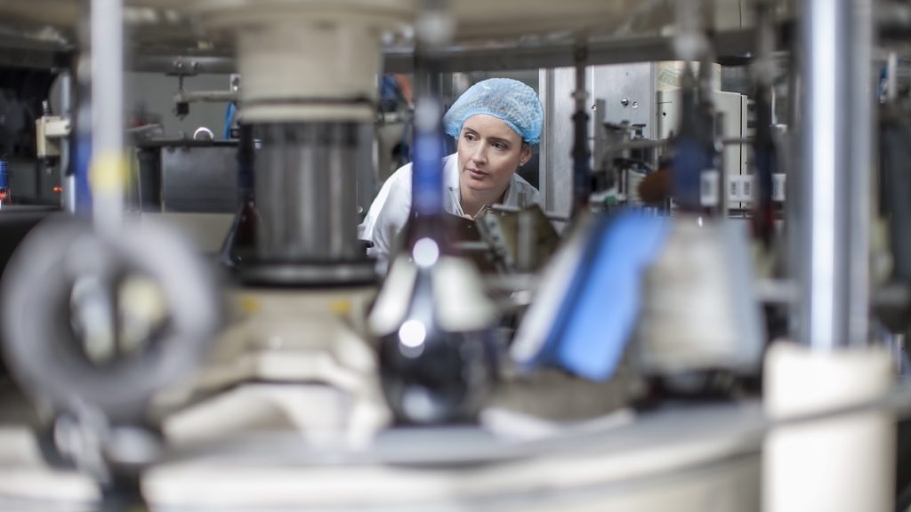 Lab technician checking equipment at packaging factory